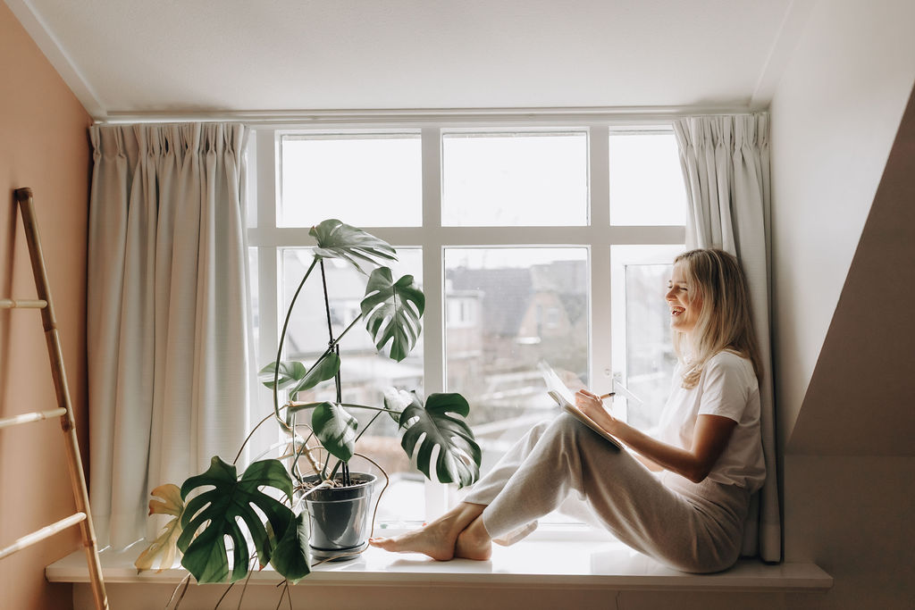 Vrouw schrijft in dagboek bij het raam tijdens ochtendroutine – Magic Morning ochtendreeks