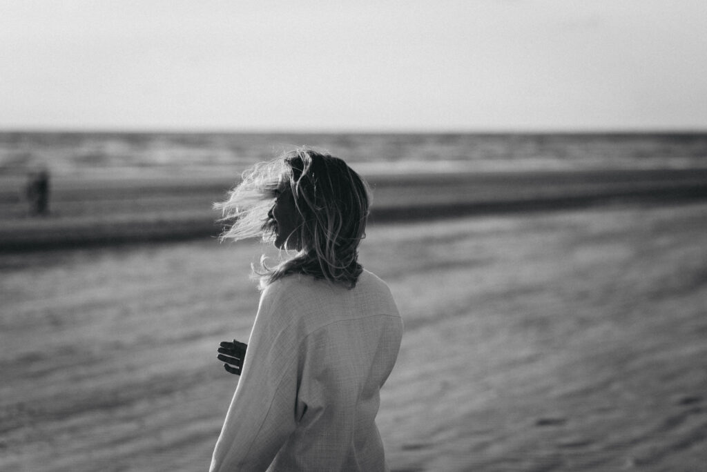 Symbolische afbeelding van Vata Dosha: vrouw op het strand in de wind.