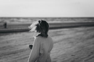 Symbolische afbeelding van Vata Dosha: vrouw op het strand in de wind.